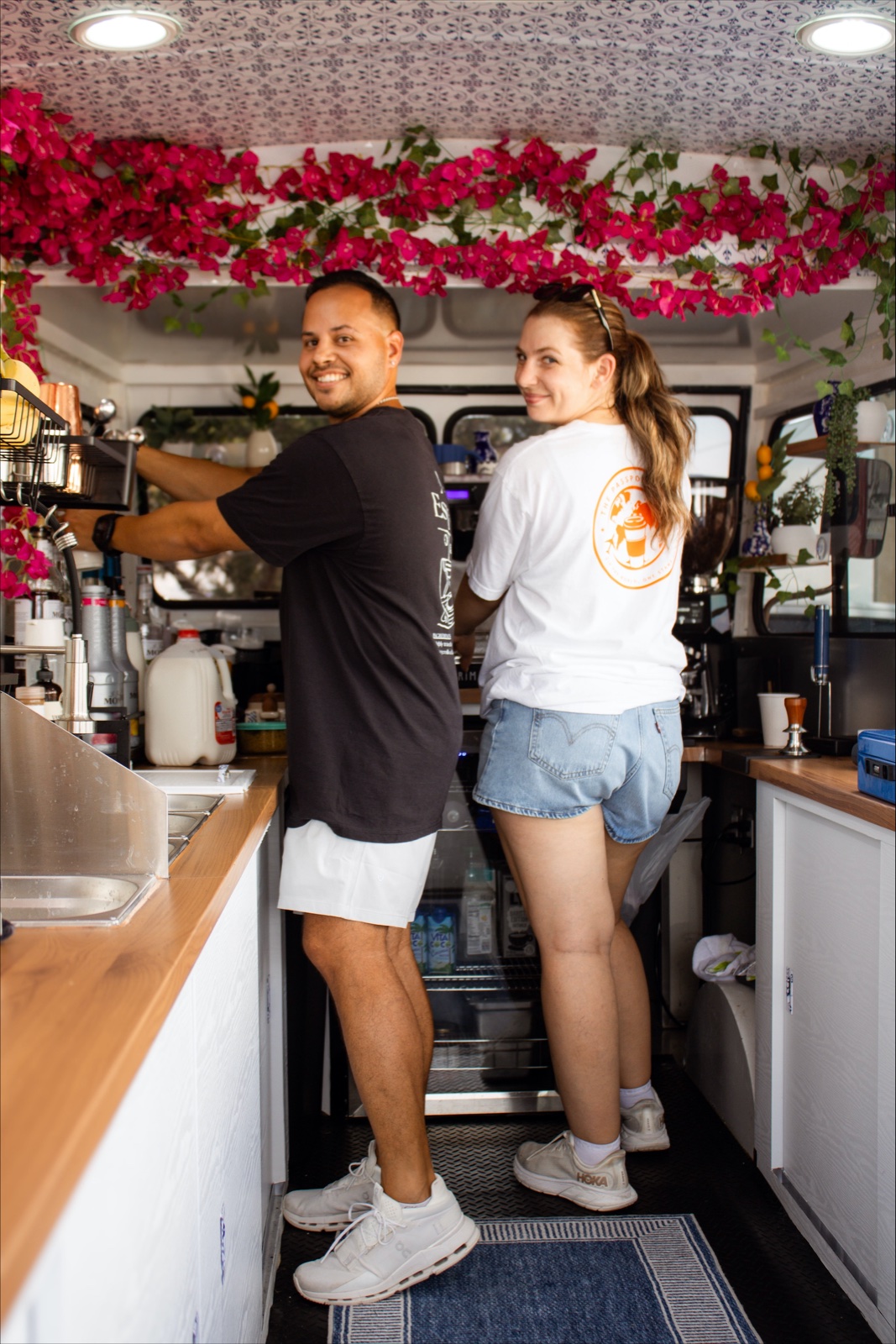 The two owners of The Passport Cafe looking back at the camera inside the truck